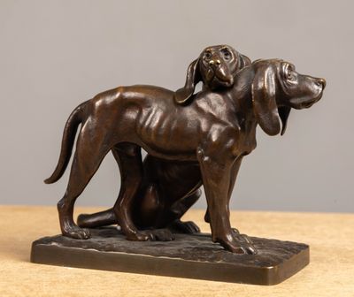 bronze statue of a dog and a cat sitting on a table