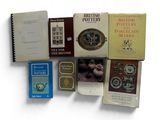 several books on a white surface with one open and the other closed