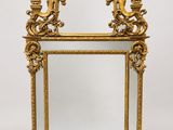 un miroir à cadre doré orné d'un motif représentant un oiseau et une fleur