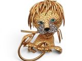 une image représentant une broche en forme de chien, en or et diamants, aux yeux verts