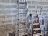 several ladders are lined up against a brick wall in a room
