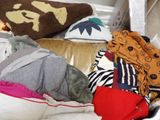 a pile of clothes that is sitting on a couch