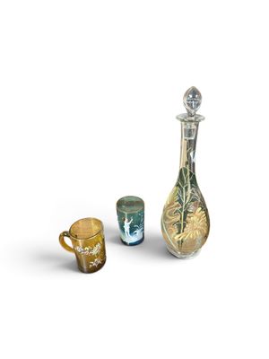 three glass vases and a glass cup on a white surface