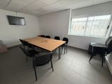 tables and chairs in a room with a flat screen tv on the wall