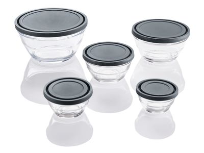 quatre bols en verre avec des couvercles noirs, posés sur une surface blanche