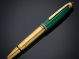 a green and gold pen with a gold tip
