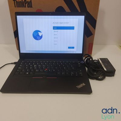 un ordinateur portable posé sur une table, avec une boîte en arrière-plan