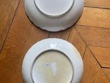 two plates that are sitting on a wooden floor