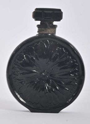 a black glass bottle with a black lid on a white surface