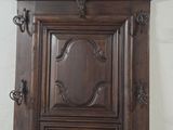 a tall wooden cabinet with a mirror on top of it