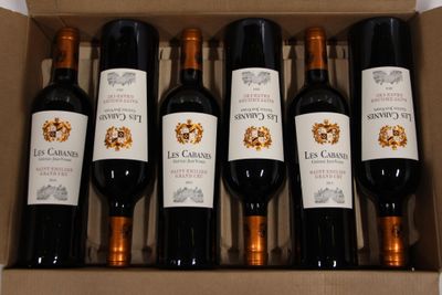 six bottles of red wine in a cardboard box on a table