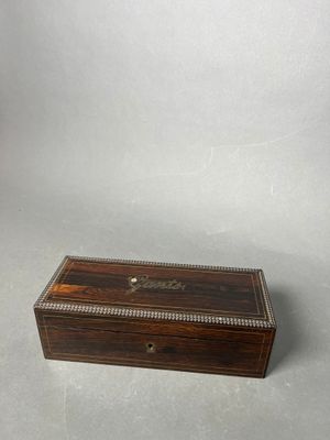 an antique wooden box with beading on the lid
