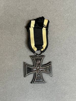 une croix de fer ornée d'un ruban noir sur un fond gris