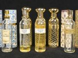 several bottles of perfume sitting next to each other on a black surface