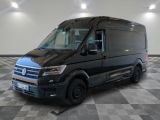 la camionnette noire est garée sur un sol en damier dans le garage