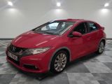 La Honda Civic rouge est garée dans une pièce dont le sol est en damier.