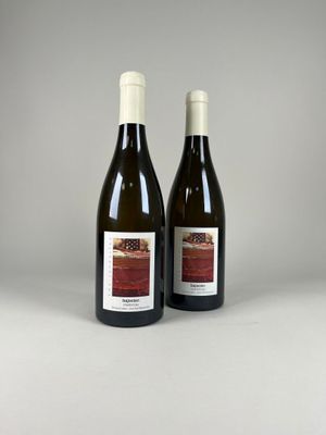 deux bouteilles de vin posées l'une à côté de l'autre sur une table
