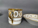two cups and a bowl are sitting next to each other on a table