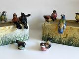 deux figurines d'oiseaux posées sur un bloc de bois