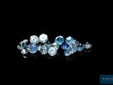 un gros plan sur un bouquet de diamants bleus posés sur une surface noire