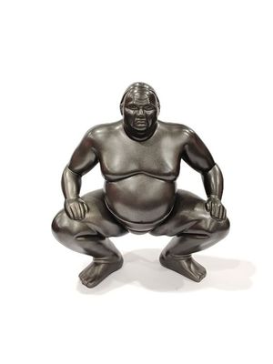 an image of a statue of a sumo sitting on his knees