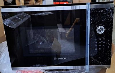 un micro-ondes qui se trouve dans un carton posé par terre