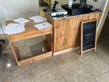 a small counter with a coffee maker and a chalk board