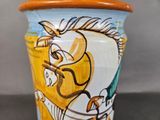 a vase that has a horse on it on a table