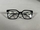 une paire de lunettes noires posée sur une surface blanche