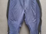 un pantalon bleu avec des fermetures éclair, suspendu à un cintre accroché au mur