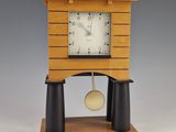 a wooden clock that is on a stand with a pendulum