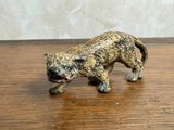 une petite figurine représentant un chat posée sur une table en bois