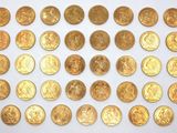 some gold coins are arranged in rows on a white surface