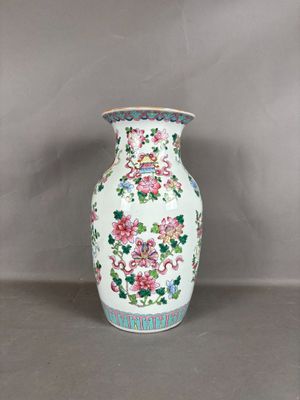 un vase blanc avec des fleurs posé sur une table