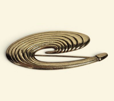 a close up of a metal brooch with a spiral design
