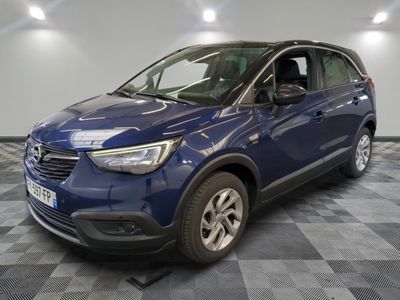 une voiture bleue est garée dans une pièce au sol à carreaux