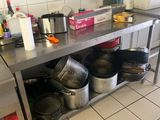 de nombreuses casseroles et poêles posées sur le plan de travail de la cuisine