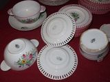a red table cloth with a bunch of dishes and cups on it