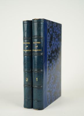 deux livres bleus posés l'un sur l'autre sur une surface blanche
