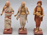 trois figurines représentant un homme, une femme et un enfant, posées sur des blocs de bois