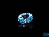 a close up of a blue diamond on a black surface