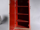 a small red cabinet with a clock on top of it