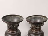 two bronze vases sitting next to each other on a table