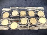 six different types of gold coins in plastic bags on a table