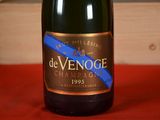 a bottle of champagne sitting on a table with a blue ribbon around it