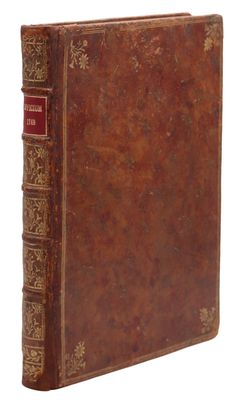 un livre ancien avec une couverture en cuir marron et des bordures dorées