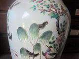 a vase with a bird design on it sitting on a table