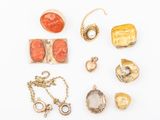 a group of gold and coral jewelry including a ring, broochle, and other items