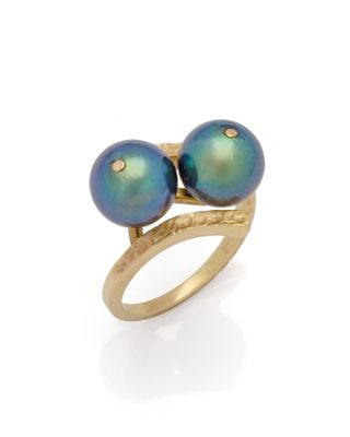 un gros plan d'une bague ornée de deux perles bleues