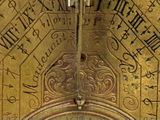 a gold clock with roman numerals on it